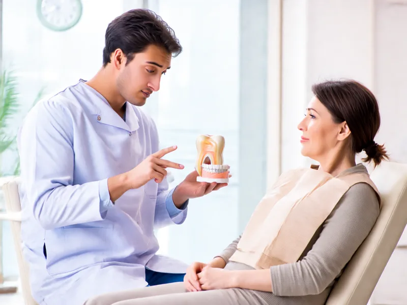 Dentist discussing a denture model with a patient