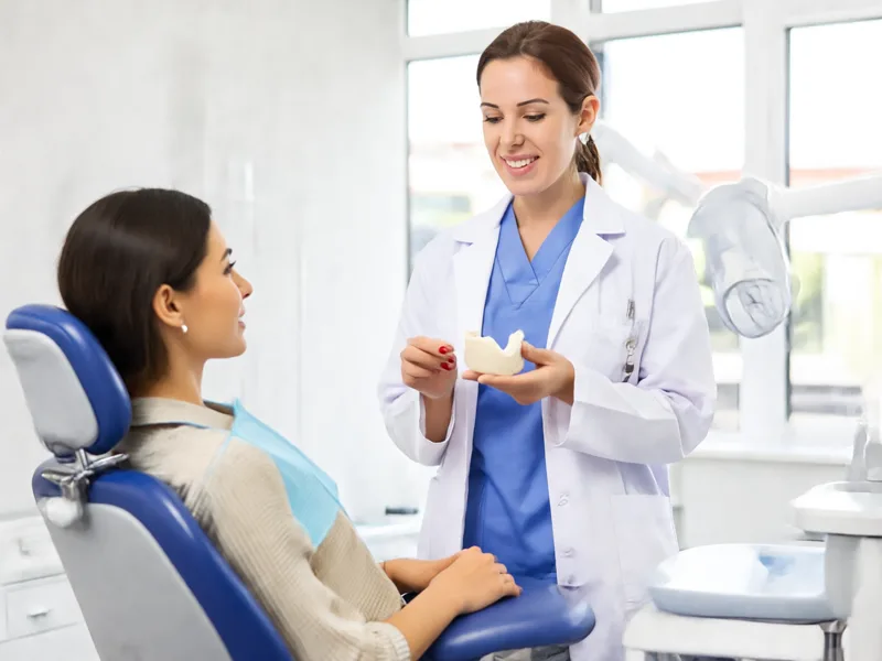 Dentist showing a patient a dental impression mould used for custom veneers